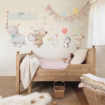 Animal Music Band fabric wall decal set featuring watercolor elephant, bear, bunny, penguin, and puppy arranged on a neutral wall above a wooden crib with pink gingham bedding