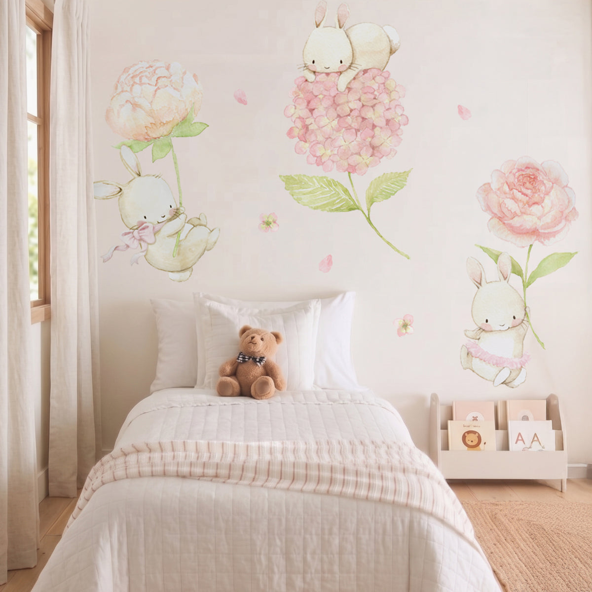 Watercolor floral bunny fabric wall decals installed above a white baby bed with a teddy bear in a bright nursery