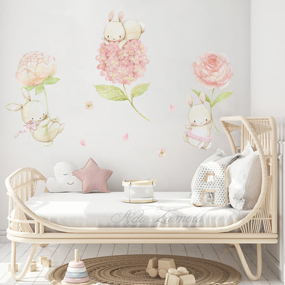 Floral bunnies fabric wall decal set featuring watercolor bunnies and peonies installed above a rattan baby crib