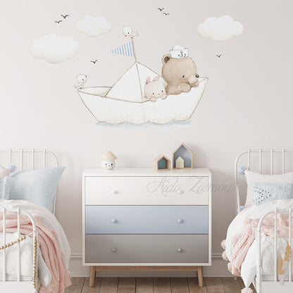 Paper Boat fabric wall decal centered above a three-drawer white and grey chest of drawers, flanked by two white metal beds with pastel bedding