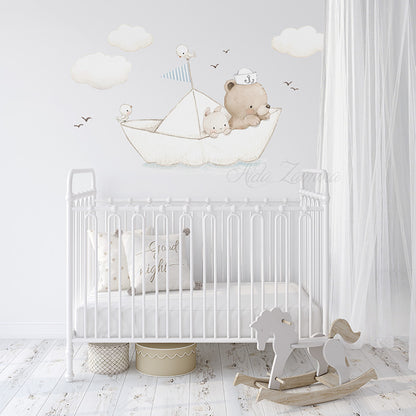 Paper boat fabric wall decal featuring teddy bear sailor, bunny, and clouds arranged on a white wall above a vintage white metal crib